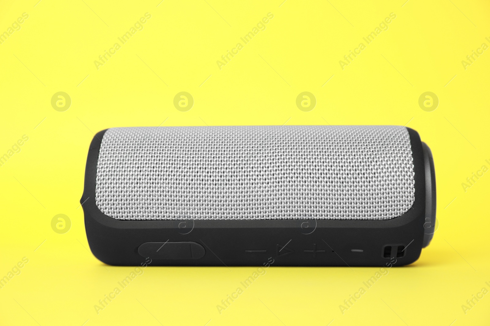 Photo of One portable bluetooth speaker on yellow background. Audio equipment