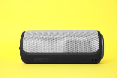 Photo of One portable bluetooth speaker on yellow background. Audio equipment