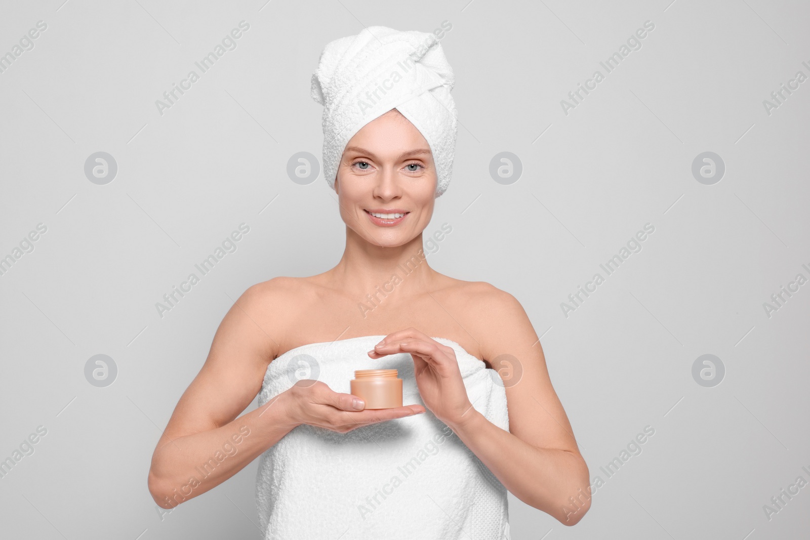 Photo of Woman with jar of body cream on white background