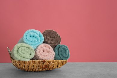 Photo of Rolled color towels on light grey stone table. Space for text