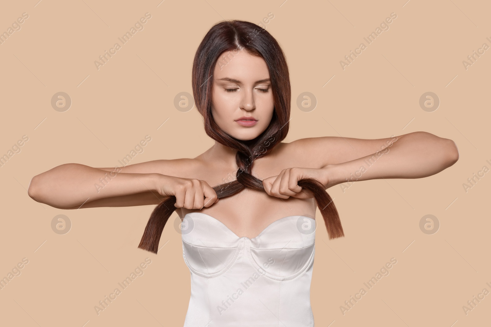 Photo of Portrait of beautiful young woman with healthy strong hair on beige background