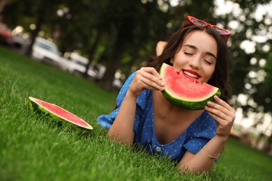 Beautiful young woman with watermelon in park on sunny day