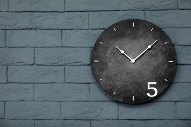 Modern clock on brick wall. Time concept