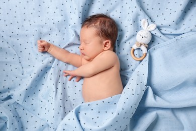 Photo of Cute newborn baby with toy bunny sleeping on bed, top view