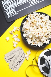 Photo of Flat lay composition with clapperboard, popcorn and tickets on color background