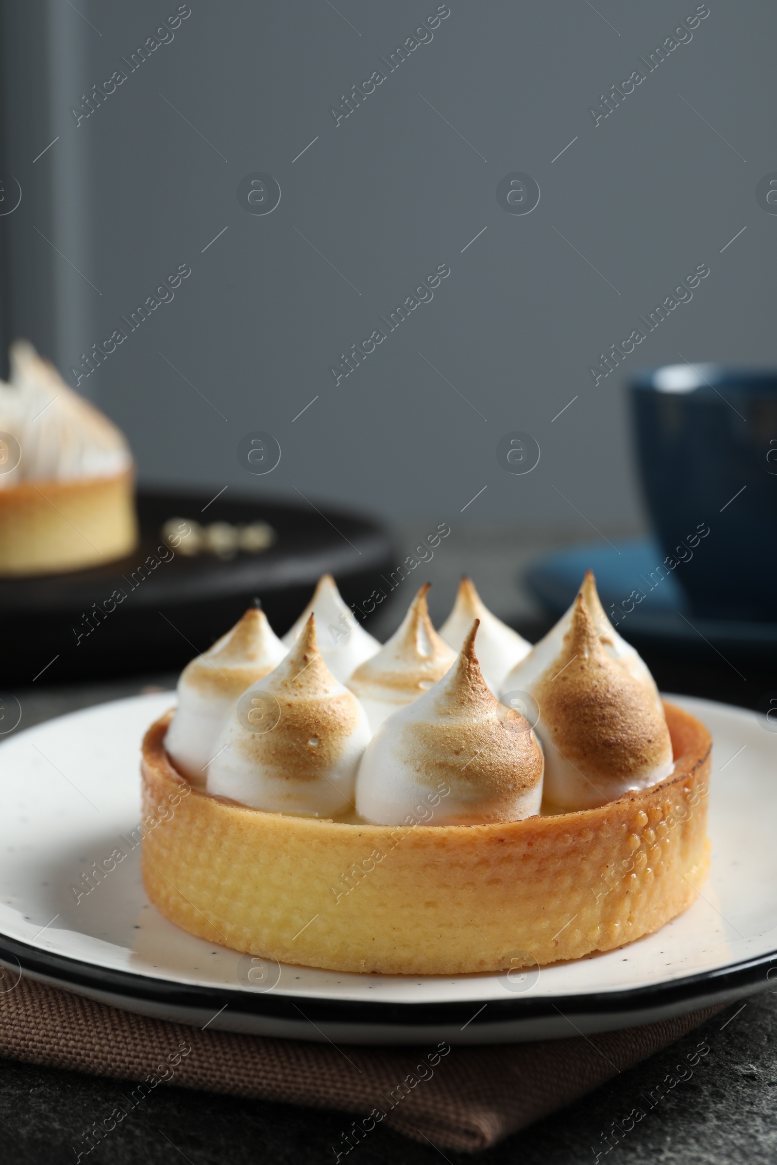 Photo of Tartlet with meringue served on table, closeup. Tasty dessert