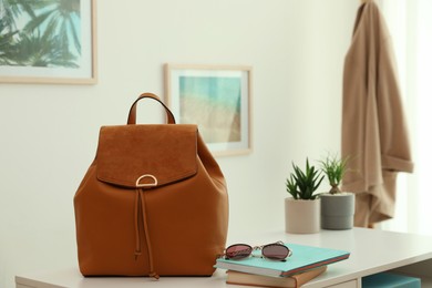 Stylish urban backpack on white table in room