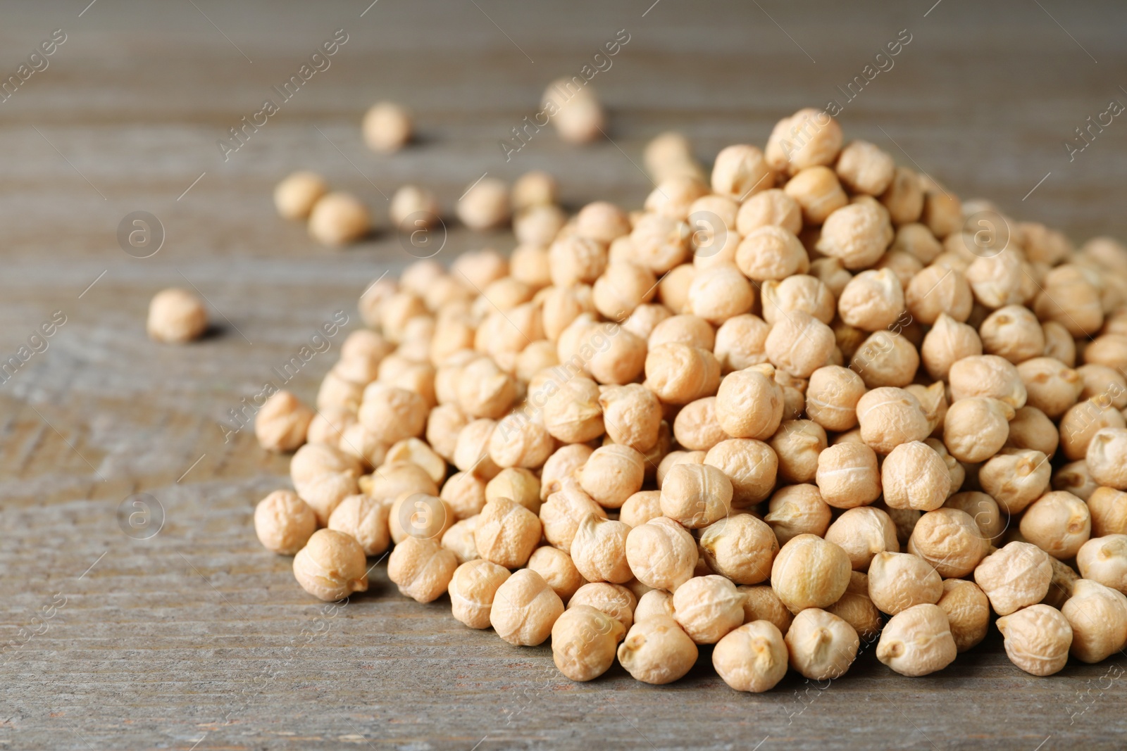 Photo of Pile of Chickpeas on wooden table, closeup. Space for text