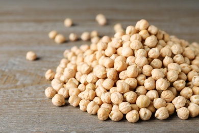 Photo of Pile of Chickpeas on wooden table, closeup. Space for text