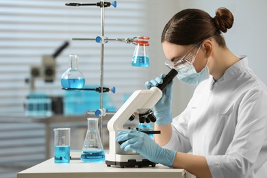 Photo of Young scientist working with microscope in laboratory