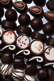 Many different delicious chocolate candies on metal surface, top view