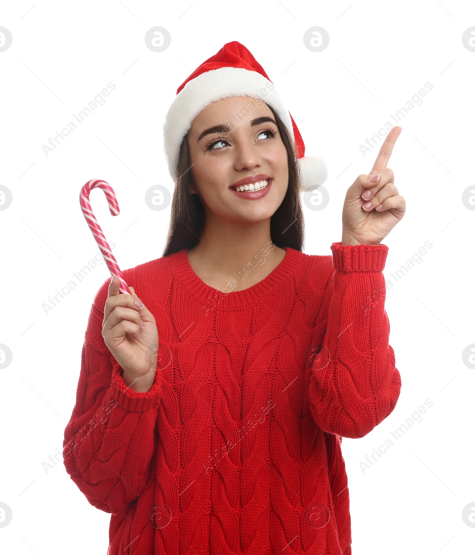 Photo of Young woman in red sweater and Santa hat with candy cane on white background. Celebrating Christmas