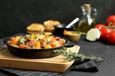 Photo of Dish with tasty ratatouille on black table