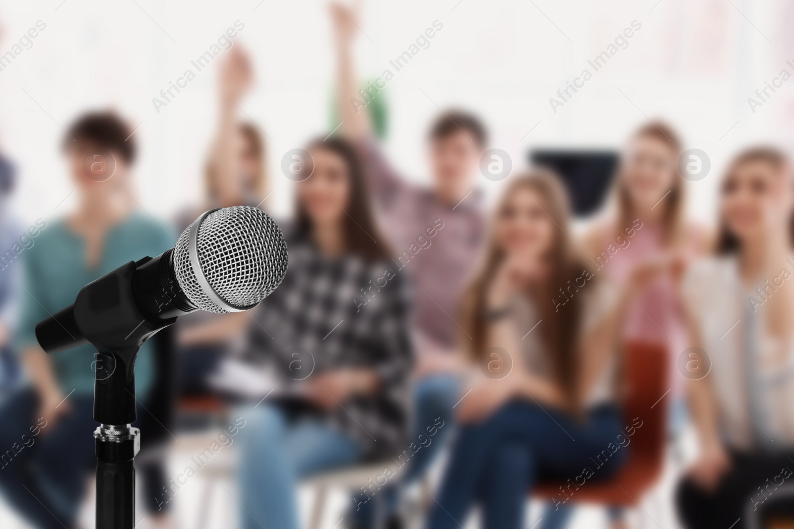 Image of Modern microphone and people at business training indoors, closeup