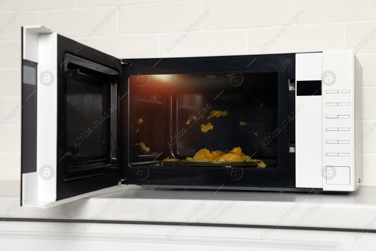 Photo of Dirty microwave oven on white countertop indoors