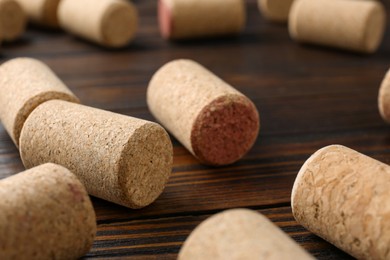 Photo of Many corks of wine bottles on wooden table, closeup