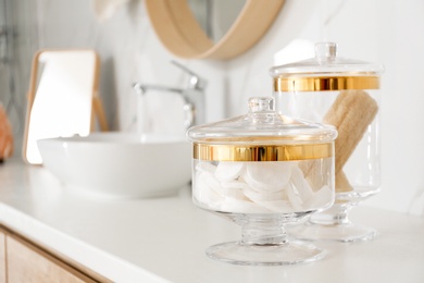 Photo of Beauty accessories near sink in bathroom. Interior elements