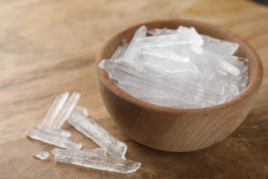 Photo of Menthol crystals in bowl on wooden background