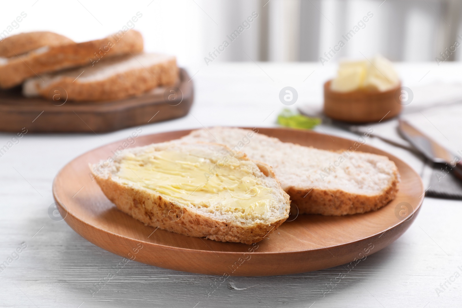 Photo of Fresh bread with tasty butter on plate