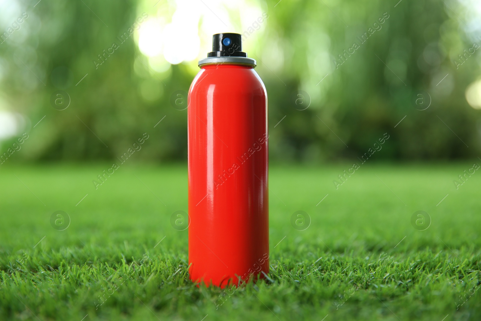 Photo of Bottle of insect repellent spray on green grass