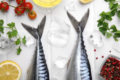 Photo of Raw mackerel, peppercorns and tomatoes on white table, flat lay