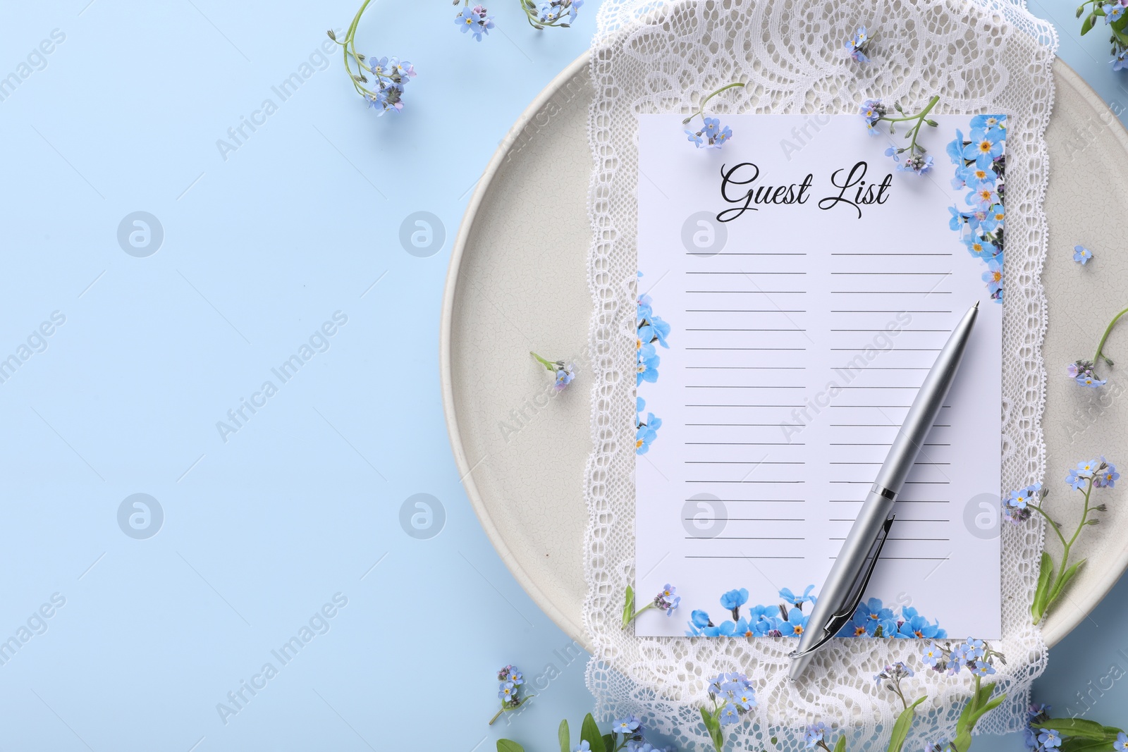 Photo of Plate with guest list, pen, lace and flowers on light blue background, flat lay. Space for text