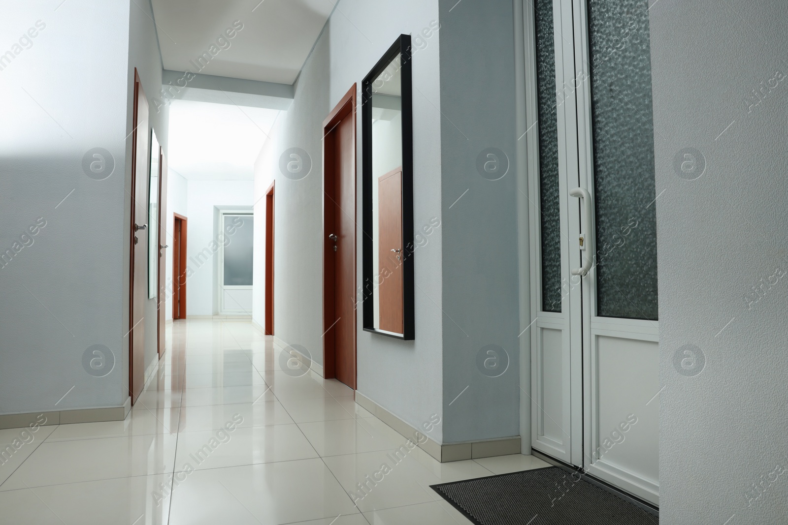 Photo of Modern empty office corridor with white walls and mirror