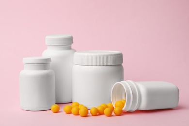Containers and scattered pills on color background