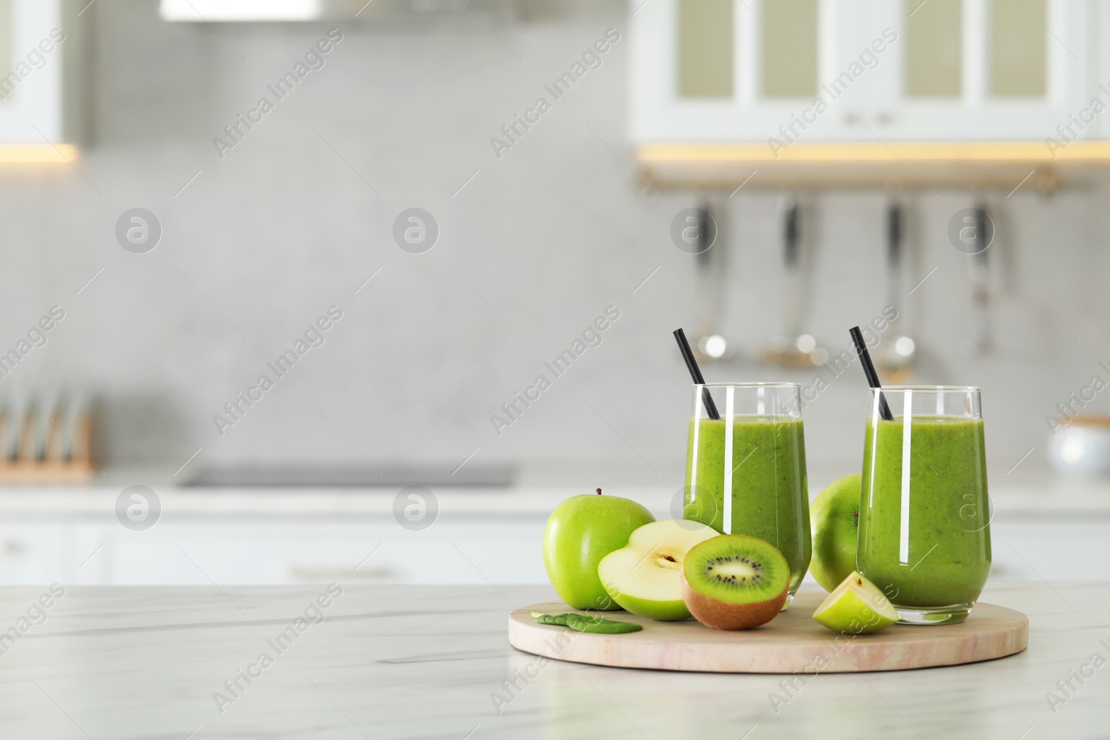 Photo of Delicious fresh smoothie and ingredients on white marble table in kitchen. Space for text