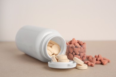 Photo of Different pet vitamins on beige table, closeup
