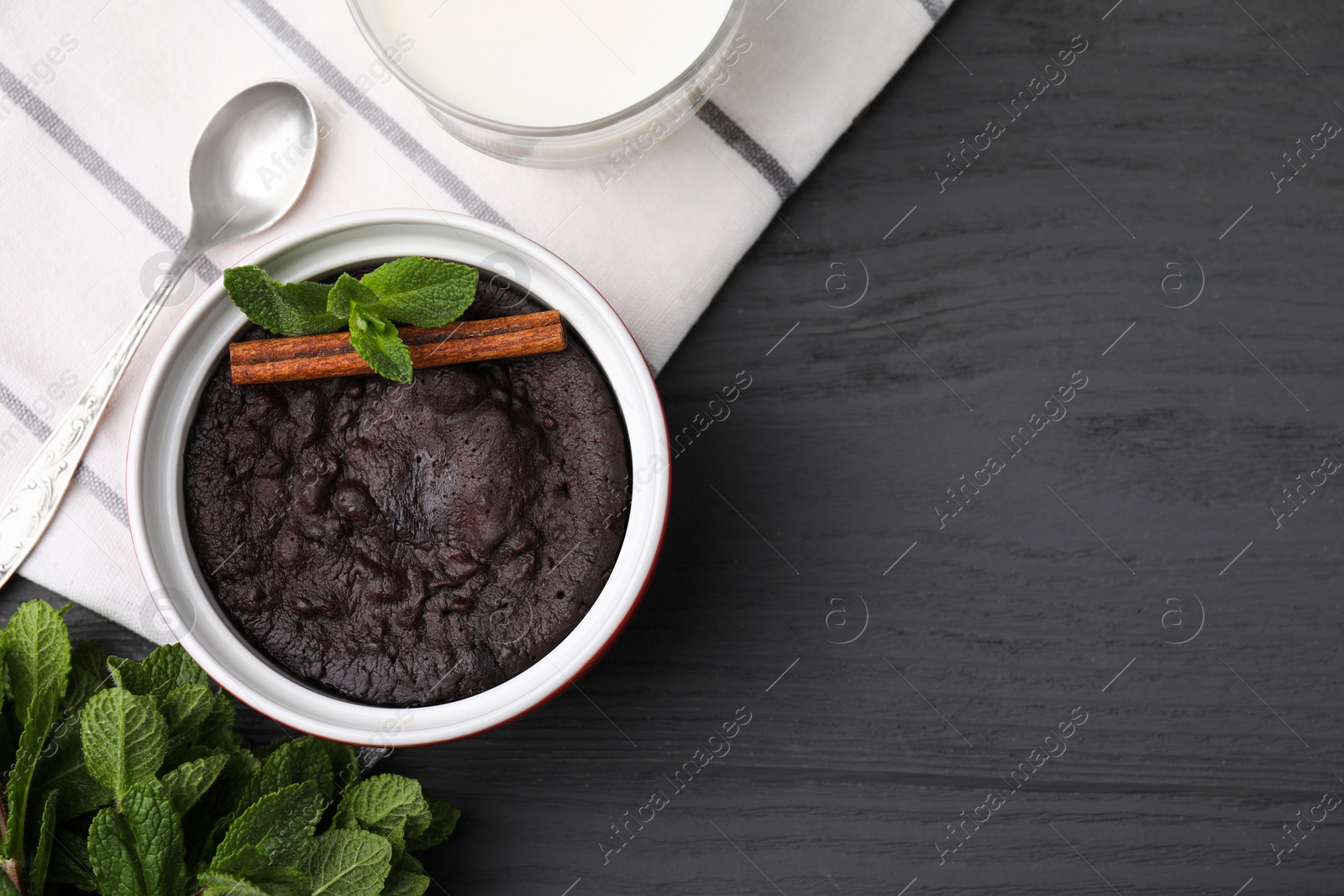 Photo of Tasty chocolate pie with mint and cinnamon stick on grey table, flat lay with space for text. Microwave cake recipe