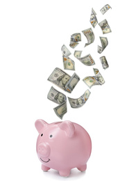 Image of Dollars falling into pink piggy bank on white background 