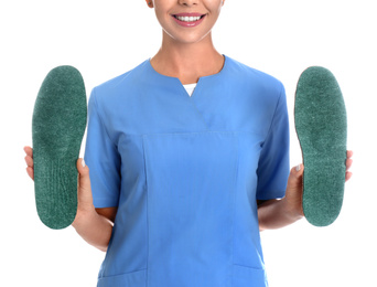 Photo of Female orthopedist showing insoles on white background, closeup