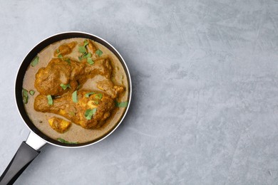 Photo of Delicious chicken with curry sauce on grey table, top view. Space for text