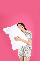 Photo of Young woman with pillow on pink background