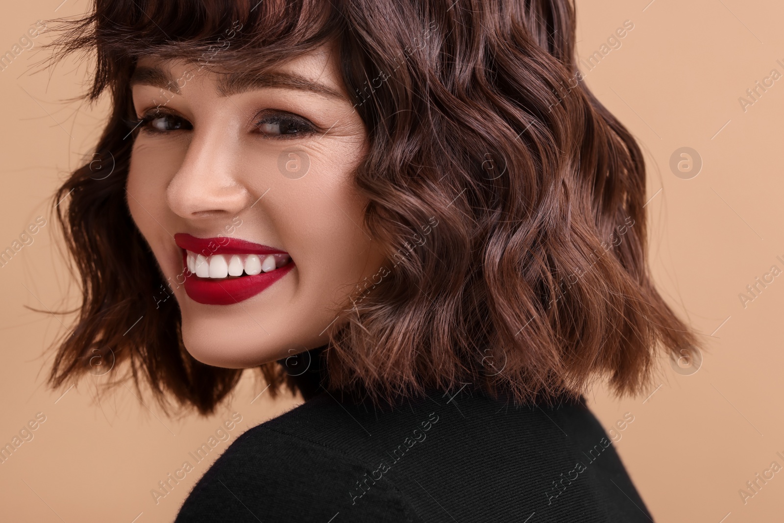 Photo of Beautiful young woman with wavy hairstyle on beige background