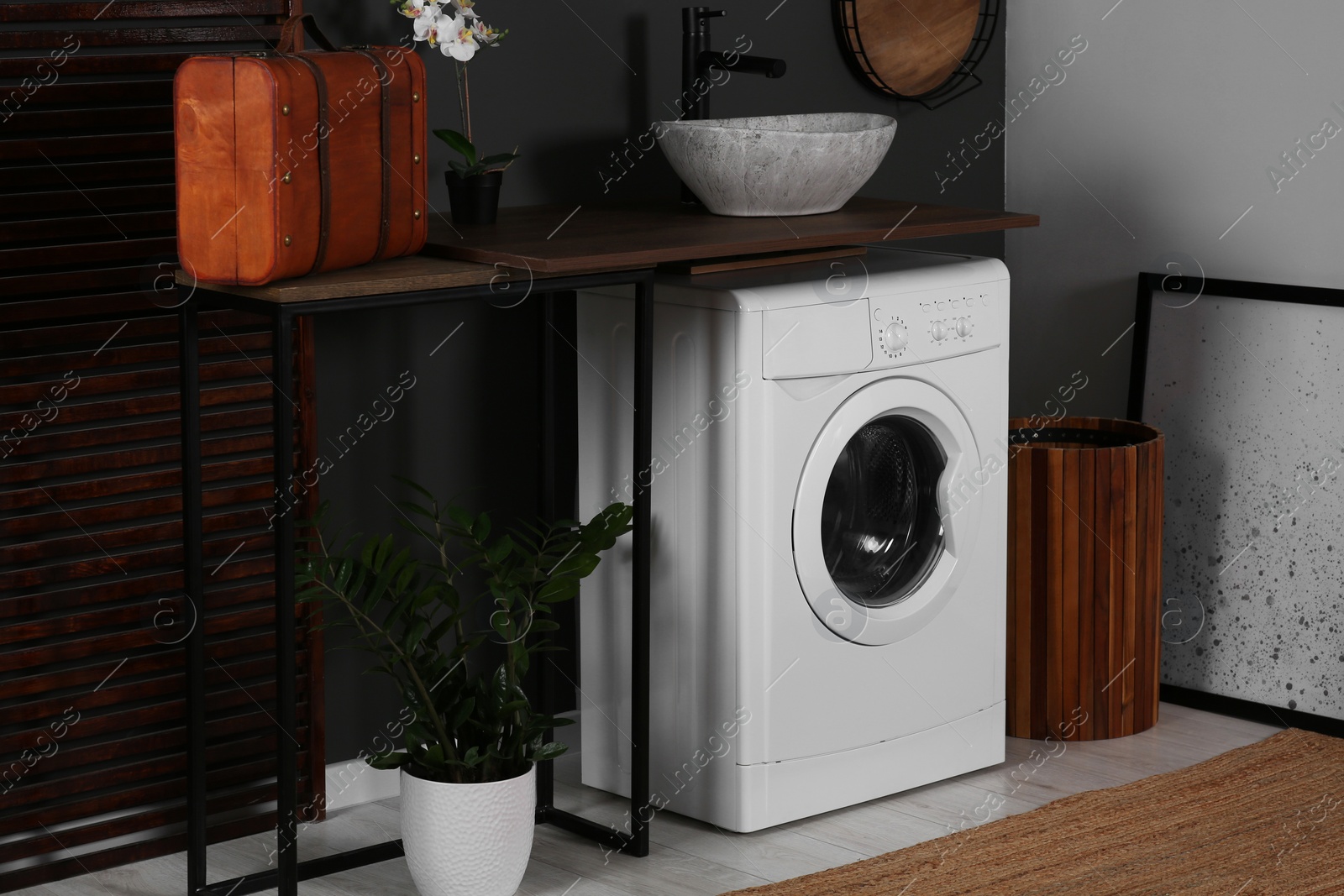 Photo of Stylish laundry room with washing machine. Interior design