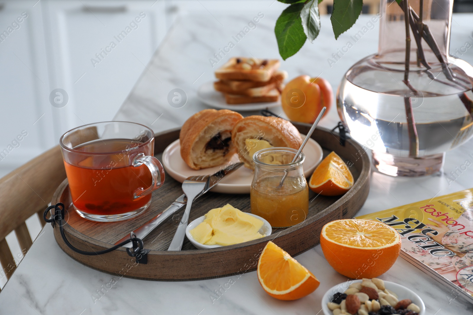 Photo of Tray with tasty breakfast on white table in morning