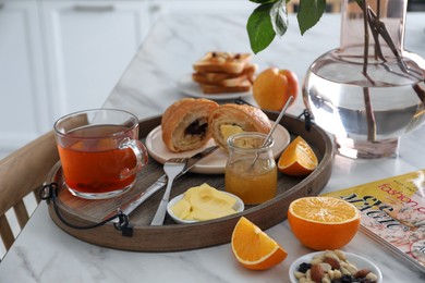 Tray with tasty breakfast on white table in morning