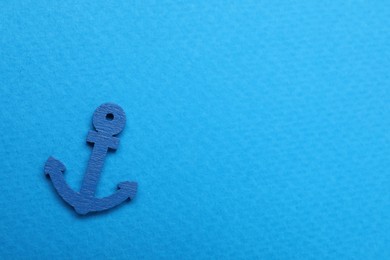 Photo of Anchor figure on light blue background, top view. Space for text