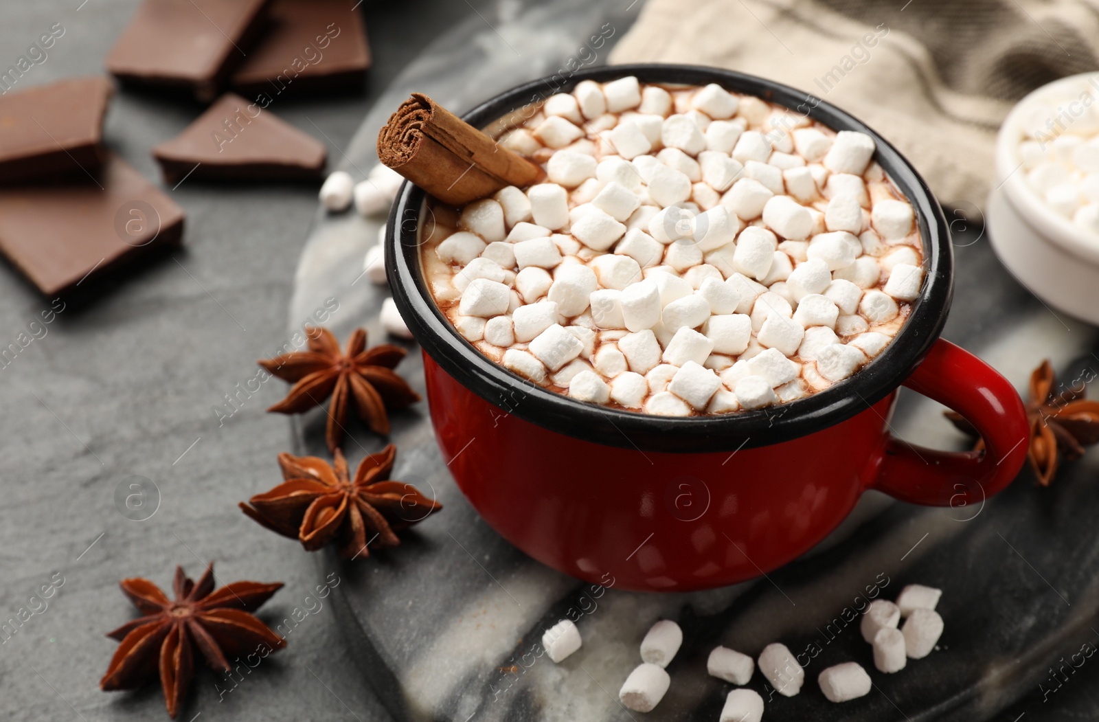 Photo of Tasty hot chocolate with marshmallows on dark textured table, closeup