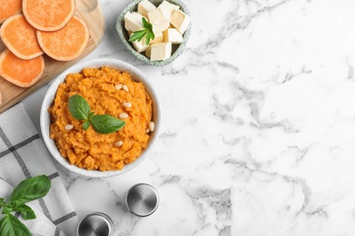 Photo of Flat lay composition with bowl of sweet potato puree and ingredients on marble table. Space for text