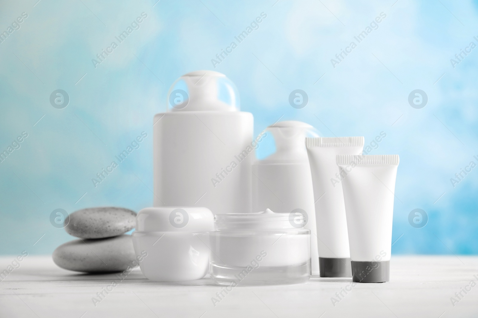 Photo of Cosmetic products on table against color background