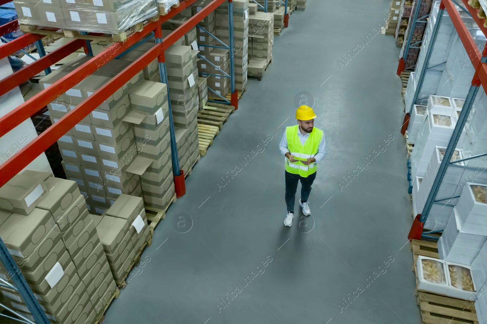 Image of Man with tablet working at warehouse, above view. Logistics center
