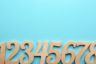Photo of Wooden numbers on light background, flat lay. Space for text