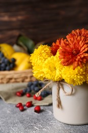 Photo of Bouquet of beautiful chrysanthemum flowers on grey table