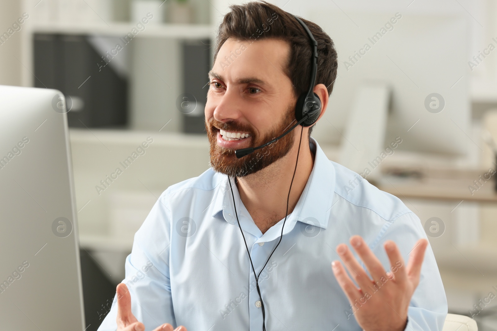 Photo of Hotline operator with headset working in office