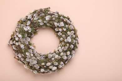 Photo of Wreath made of beautiful willow flowers on beige background, top view. Space for text