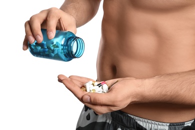Photo of Man with bottle of pills on white background, closeup. Doping concept