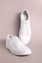 Photo of Pair of stylish white sneakers on grey background